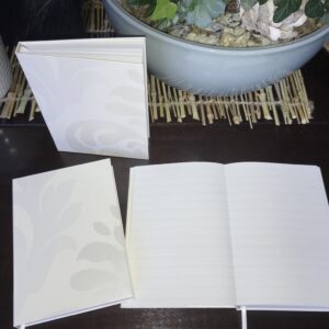 Een smetteloos ivoor wit notitieboek met een gelinieerde pagina's, perfect voor het bijhouden van memoires en adressen.