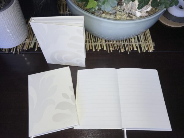 Een smetteloos ivoor wit notitieboek met een gelinieerde pagina's, perfect voor het bijhouden van memoires en adressen.